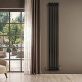 Traditional black 4 column radiator with brass valves, standing tall against a light wall, enhancing a modern living space