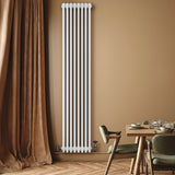 Tall white traditional 4 column radiator mounted on a wall, complemented by elegant valves, set against a warm beige backdrop
