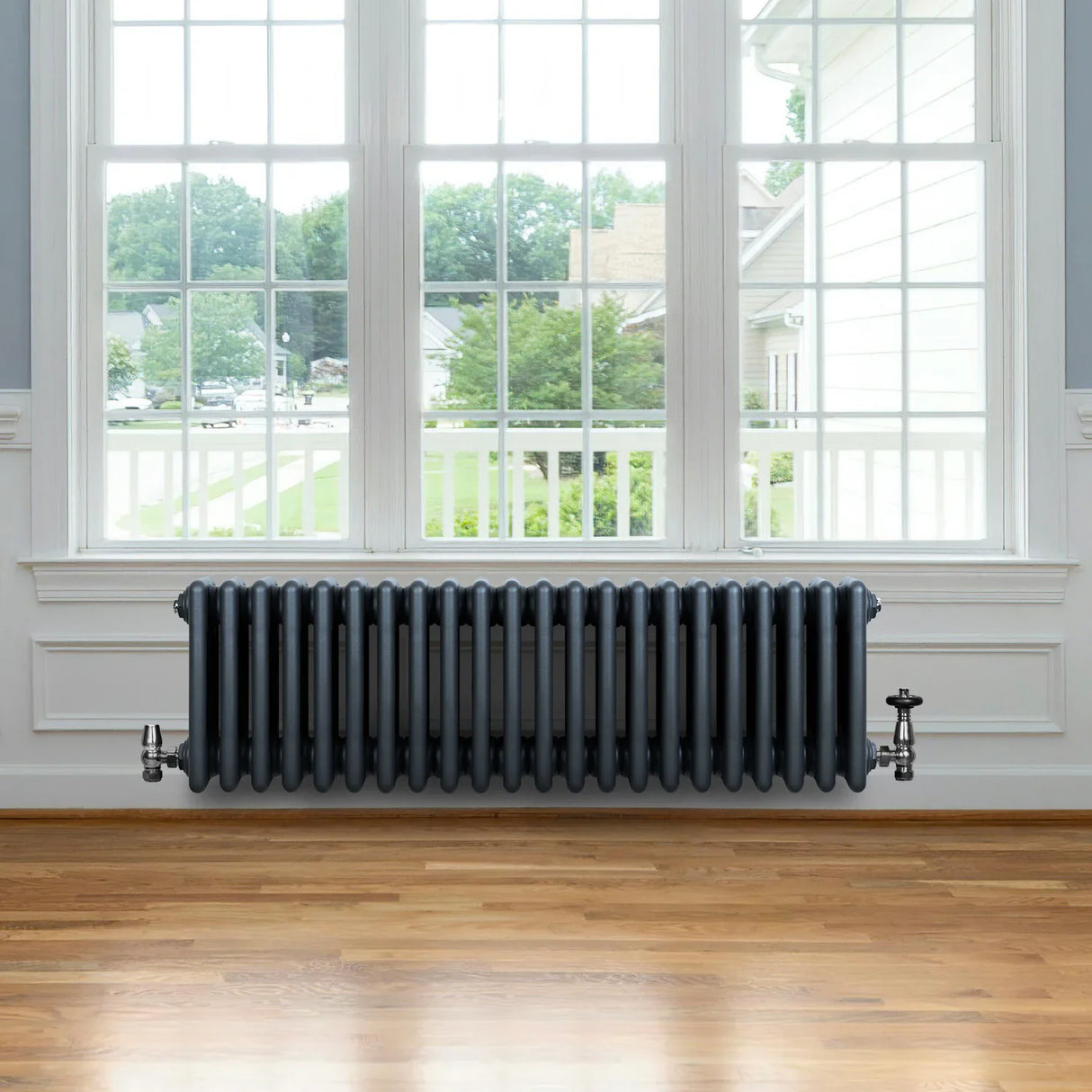 Traditional anthracite 4 column radiator, 300 x 1010mm, featuring a sleek design, installed beneath a large window in a bright room