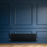Traditional anthracite 4 column radiator mounted on a deep blue wall, featuring a sleek, modern design with a textured finish
