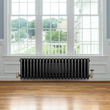 Traditional black 4 column radiator, 300 x 1010mm, featuring a sleek design with polished brass valves, set against a bright window backdrop