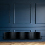 Traditional anthracite 4 column radiator, 300 x 1505mm, featuring a sleek, matte finish against a deep blue wall and wooden floor