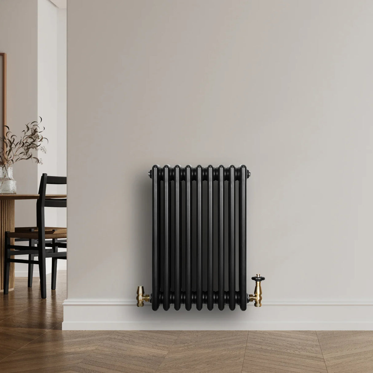 Traditional black 4 column radiator, 600 x 425mm, featuring a sleek design and brass valves, mounted on a light wall in a modern interior