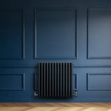 Traditional 4 column radiator in anthracite grey, mounted on a deep blue wall, showcasing a sleek, vintage design and elegant finish