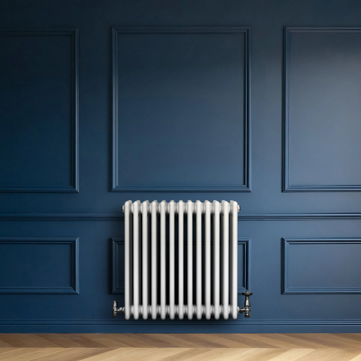 Traditional white 4 column radiator against a deep blue wall, featuring smooth, rounded edges and a sleek, modern design