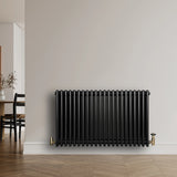 Traditional black 4 column radiator, 600 x 1010mm, featuring a sleek design with a glossy finish, mounted against a neutral wall