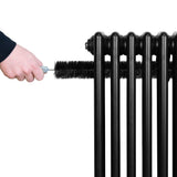 Traditional black 4 column radiator with a hand using a brush for cleaning, showcasing its sleek design and sturdy structure
