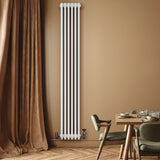 Traditional white 4 column radiator, 1800 x 290mm, mounted on a wall with a warm beige backdrop and stylish dining area furniture