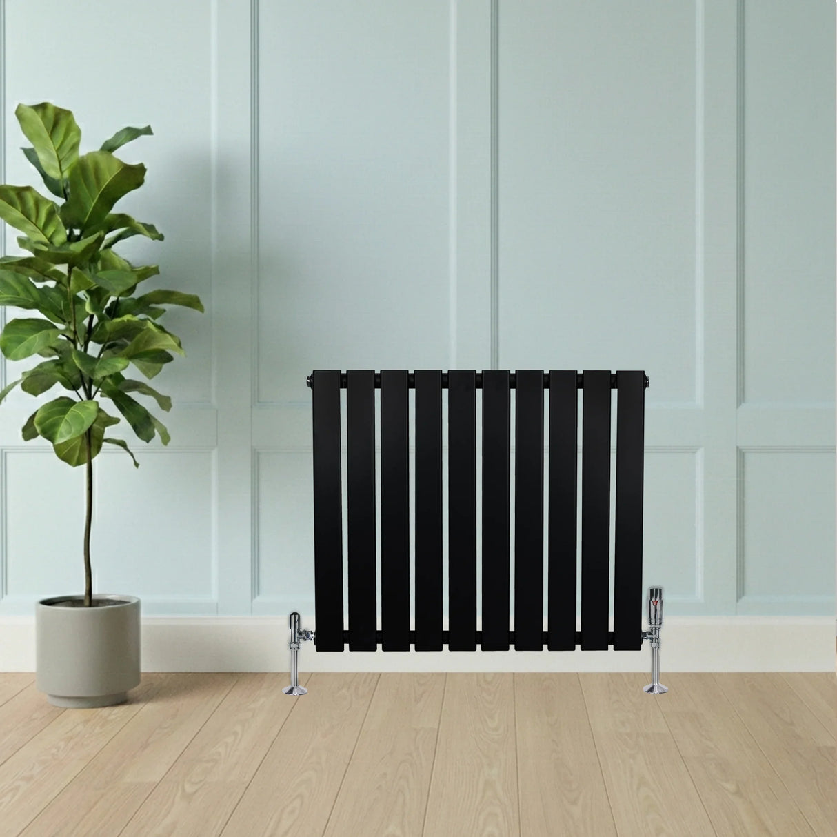 Flat black single column radiator, 600 x 700mm, featuring sleek vertical slats, positioned against a light blue wall with a plant nearby