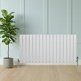 Flat single column radiator in sleek white finish, 600 x 1190mm, with vertical slats and chrome valves, positioned beside a potted plant on wooden floor
