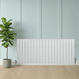 Flat single column radiator in white, 600 x 1400mm, featuring sleek vertical lines, mounted on stylish feet, beside a potted plant