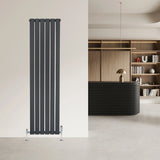 Flat single column radiator in anthracite grey, featuring vertical slats and a sleek design, mounted on a light wall in a modern interior