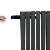 Flat single column radiator in anthracite grey, featuring sleek vertical panels and a hand adjusting the valve at the top