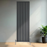 Flat black single column radiator, 1800 x 560mm, featuring sleek vertical lines and chrome valves, set against a modern interior backdrop
