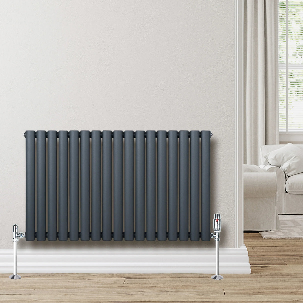 Oval single column radiator in anthracite grey, featuring sleek vertical bars and polished chrome valves, mounted on a light wall