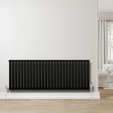 Sleek black oval single column radiator, 600 x 1620mm, mounted on a white wall, complementing a modern interior with wooden flooring