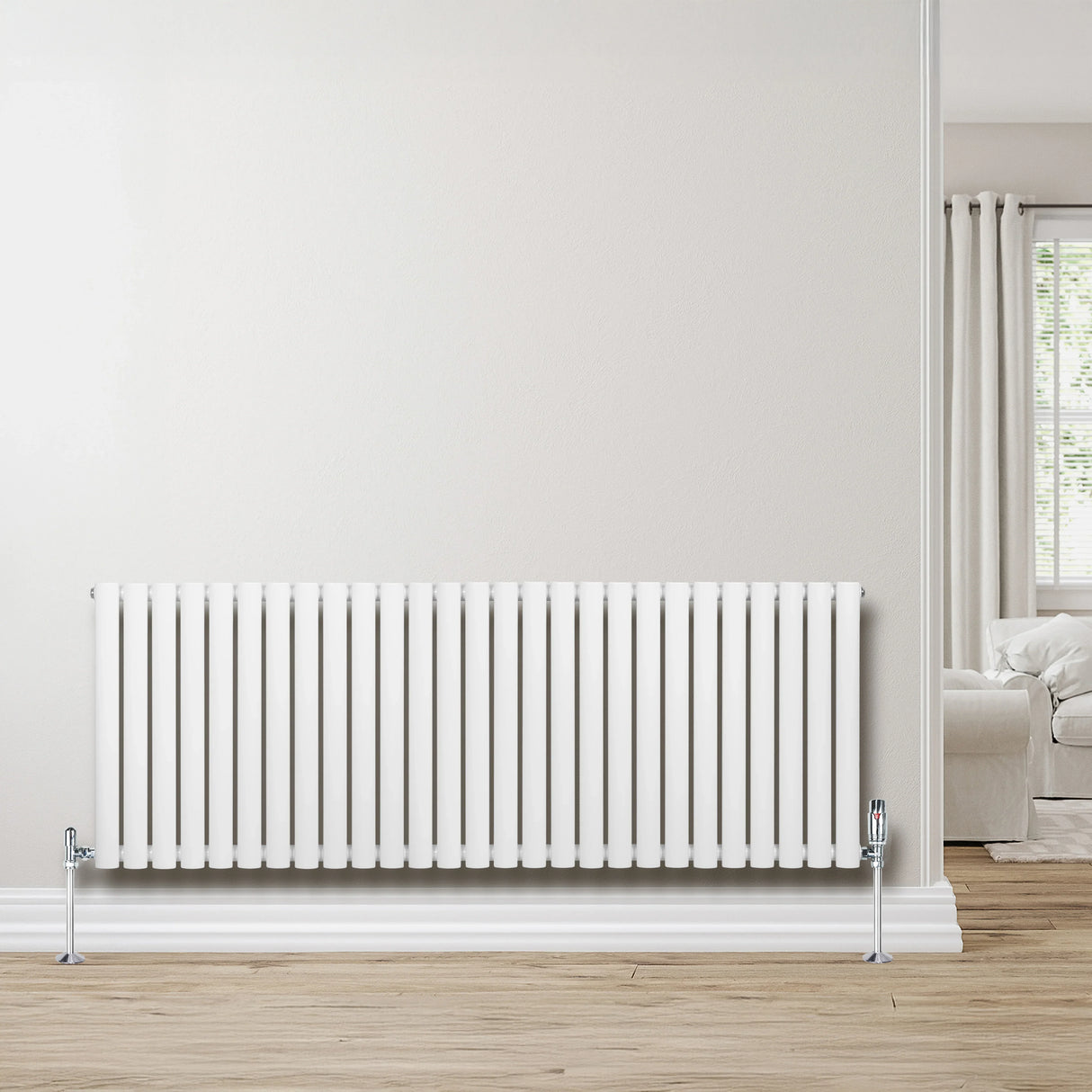 Sleek white oval single column radiator, 600 x 1620mm, mounted on a light wood floor, enhancing a modern living space with natural light