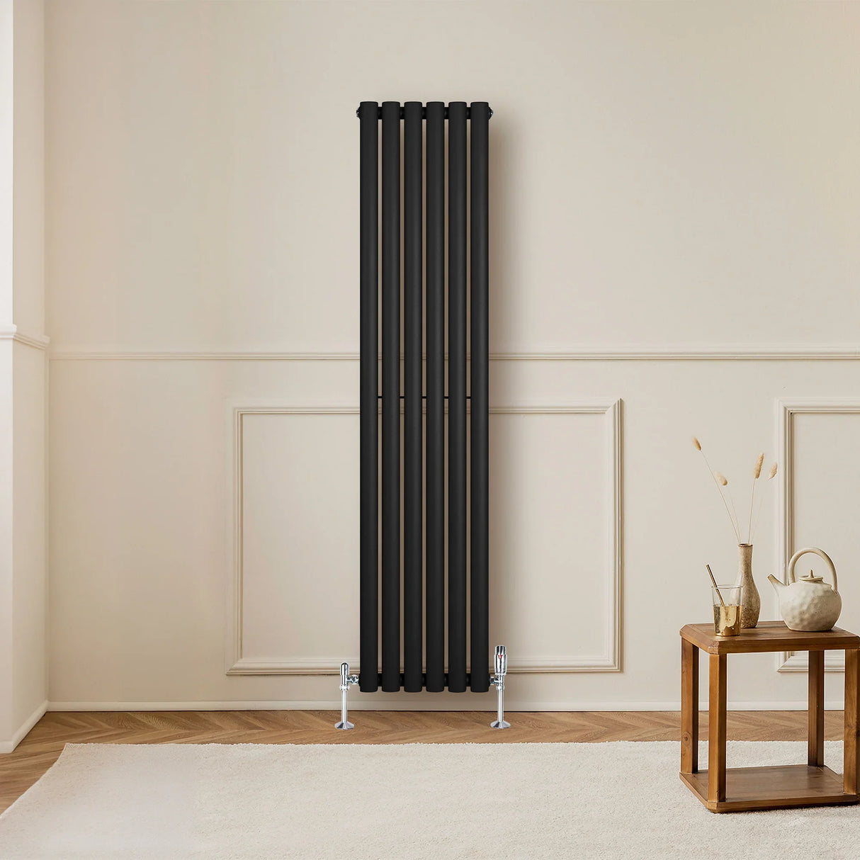 Sleek black oval single column radiator, 1600 x 360mm, mounted on a light wall, complementing a cozy living room setting