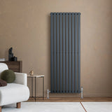 Oval single column radiator in anthracite grey, 1600 x 600mm, mounted on a textured wall, complementing modern interior decor