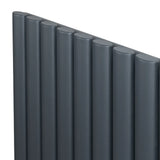 Anthracite grey oval single column radiator with a sleek, modern design, featuring smooth, rounded edges and a textured finish