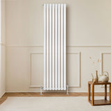 Sleek white oval single column radiator, 1800 x 480mm, mounted on a wall, enhancing a modern interior with warm wooden accents