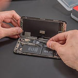 Hands using the ilabPRO 120 Piece Precision Screwdriver Set to repair a smartphone, showcasing various tools and intricate components