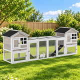 Grey 2-in-1 outdoor rabbit hutch featuring two levels, mesh panels, and a spacious run, set in a lush green garden environment