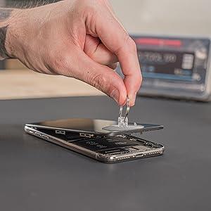 Precision screwdriver set in use, removing a smartphone screen with a suction cup tool, showcasing sleek design and versatility